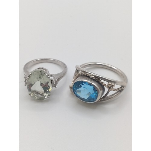 304 - A silver and green amethyst (prasiolite) dress ring, size L 1/2, together with a white metal and blu... 