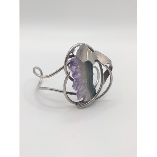 299 - A white metal bangle set with amethyst geode.