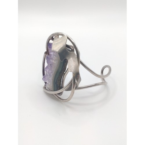 299 - A white metal bangle set with amethyst geode.