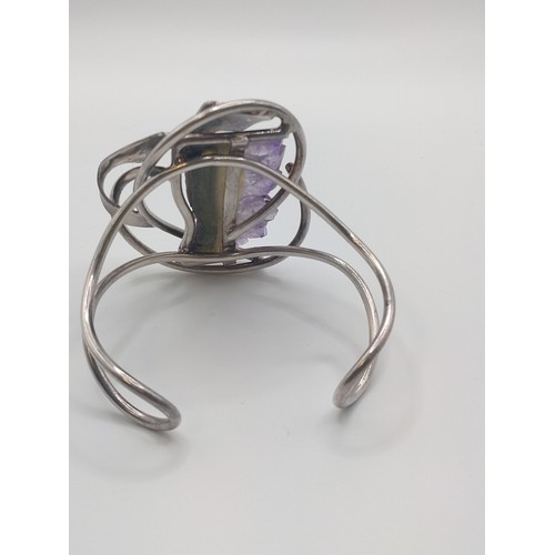 299 - A white metal bangle set with amethyst geode.