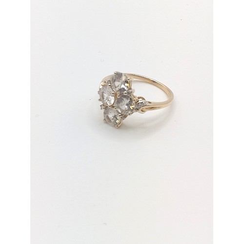 298 - A 9ct yellow gold and CZ ring, set with four mixed round-cut stones, with small diamond accents, siz... 