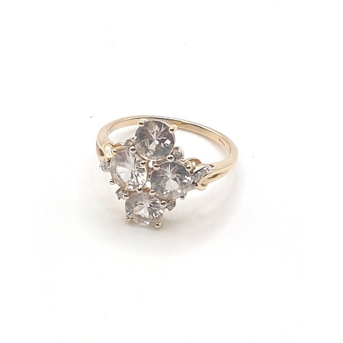 298 - A 9ct yellow gold and CZ ring, set with four mixed round-cut stones, with small diamond accents, siz... 