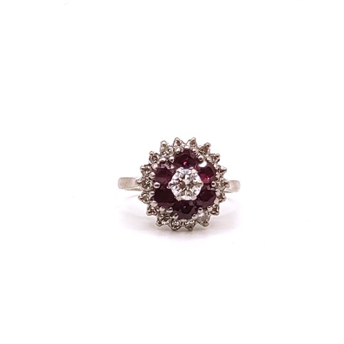 309 - An 18ct white gold, diamond, and ruby cluster ring, set with a round brilliant-cut diamond measuring... 