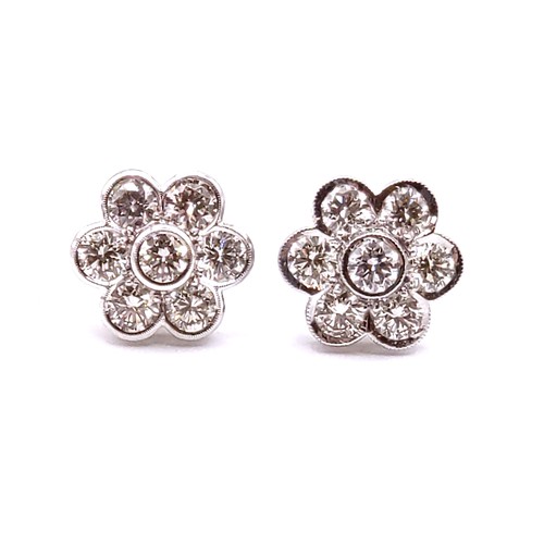 293 - A pair of 18ct white gold and diamond floral cluster ear studs, the round brilliant-cut diamonds of ... 