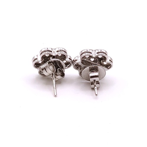 293 - A pair of 18ct white gold and diamond floral cluster ear studs, the round brilliant-cut diamonds of ... 