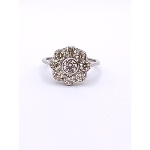 310 - A platinum and diamond floral cluster ring, set with nine round brilliant-cut diamonds of approximat... 