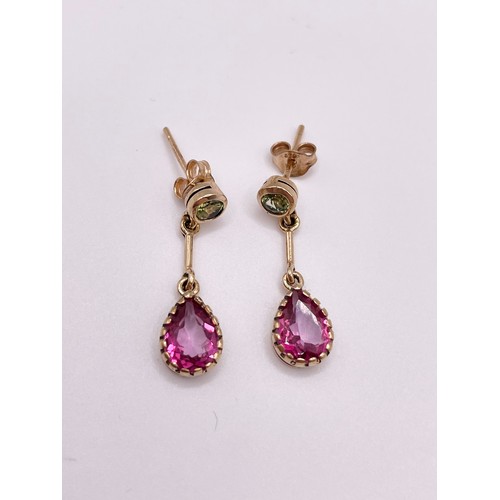 288 - A pair of 9ct yellow gold, pink topaz, and peridot drop earrings, each collet-set with a round-cut p... 