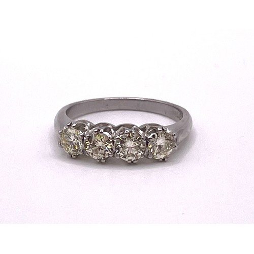 284 - A platinum and diamond four stone ring, set with four round brilliant-cut diamonds of approximately ... 