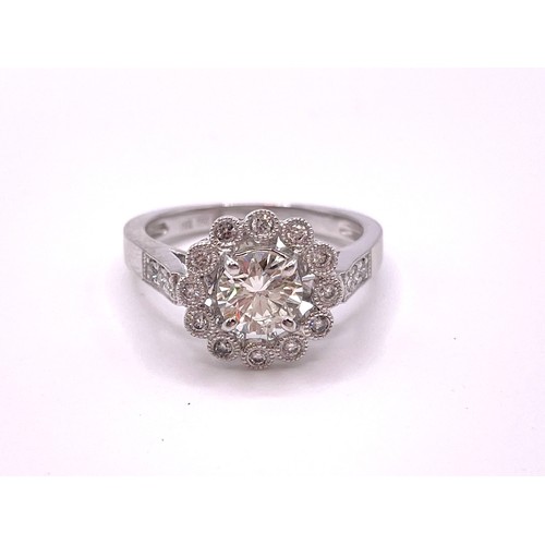 300 - An 18ct white gold and diamond halo cluster ring, centered with a round brilliant-cut diamond of app... 