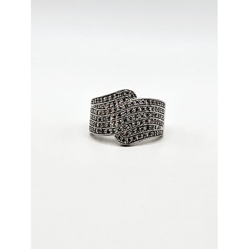 303 - An 18ct white gold and diamond cocktail ring, the crossover design pave-set with round brilliant-cut... 