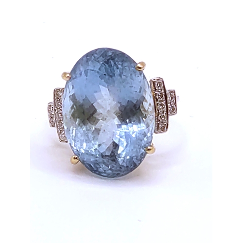 301 - An 18ct yellow gold, diamond, and aquamarine cocktail ring, set with a mixed oval-cut aquamarine of ... 