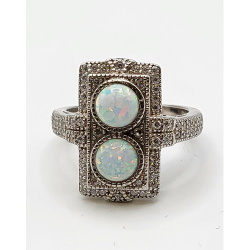 248 - A silver, cubic zirconia, and opalite panel ring, in the Art Deco style, set with two round cabochon... 