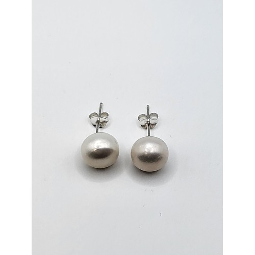 268 - A pair of silver and freshwater pearl stud earrings, the  pearls approximately 10 mm.