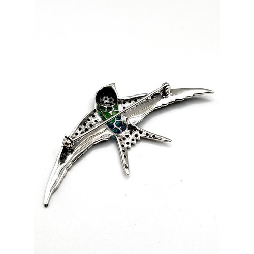 271 - A silver, marcasite, and plique-a-jour style brooch in the form of a bird, 7 cm wide.