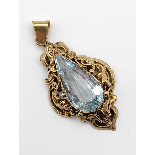 277 - A late Victorian yellow gold and aquamarine pendant, set with a pear-cut aquamarine within an ornate... 