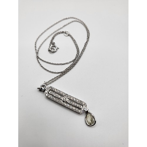 279 - An 18ct white gold and diamond Art Deco pendant, the lozenge-shaped central segment set with round b... 