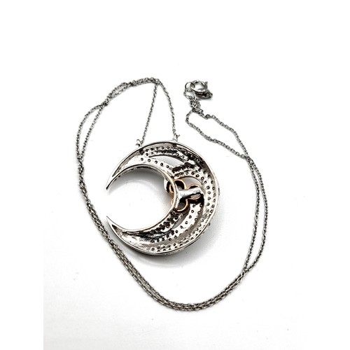 282 - A 9ct white gold, diamond, and moonstone pendant in the form of a crescent moon, pave-set with round... 