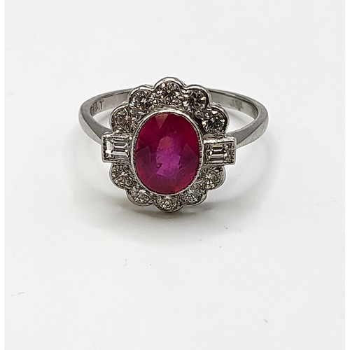 283 - A platinum, diamond, and ruby cocktail ring, set with a mixed oval-cut ruby of approximately 1.65 ca... 