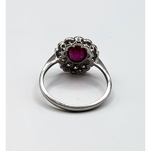 283 - A platinum, diamond, and ruby cocktail ring, set with a mixed oval-cut ruby of approximately 1.65 ca... 