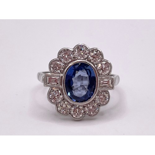 286 - A platinum, diamond, and sapphire cluster ring, set with a mixed oval-cut sapphire within a border o... 