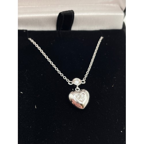 291 - An 18ct white gold and diamond heart-shaped pendant, the rounded pendant inset with three diamond ac... 