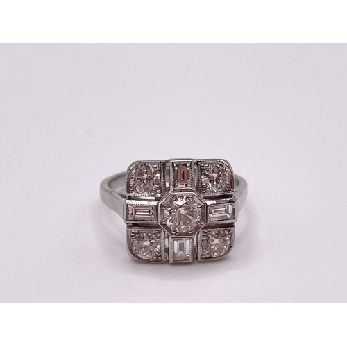 294 - A platinum and diamond ring, set with a round-cut diamond, surrounded with four baguette-cut diamond... 