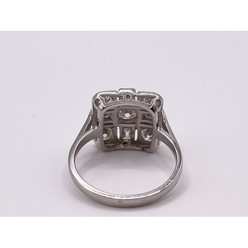 294 - A platinum and diamond ring, set with a round-cut diamond, surrounded with four baguette-cut diamond... 