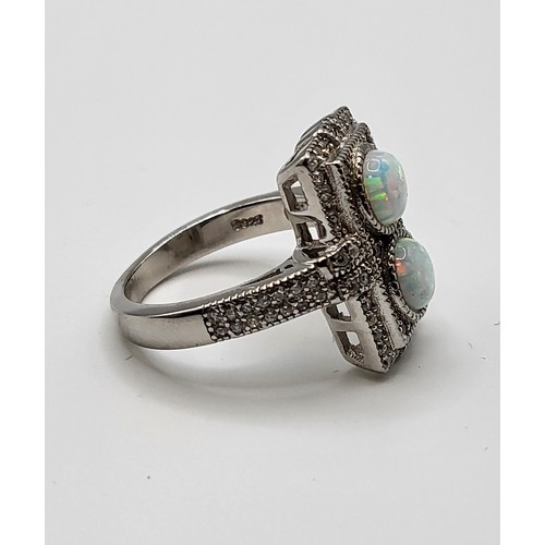 246 - A silver, cubic zirconia, and opalite panel ring, in the Art Deco style, set with two round cabochon... 