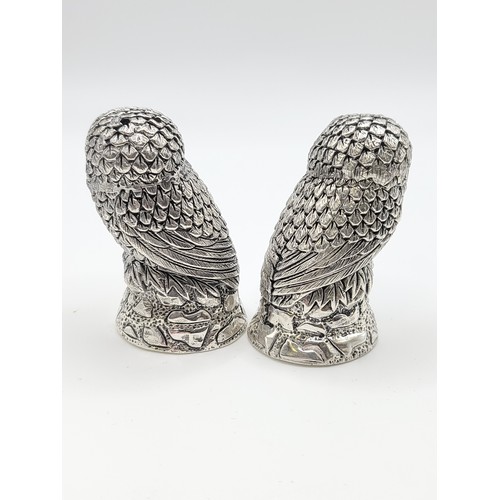 229 - A pair of novelty silver owl condiments, the seated owls on naturalistic perches, 5 cm high.