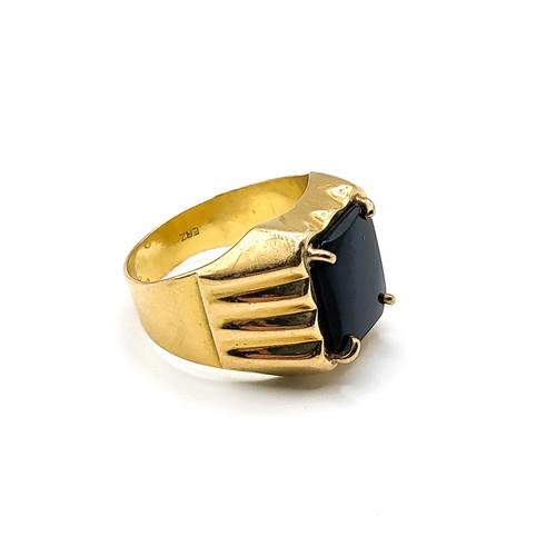 281 - An 18ct yellow gold and black onyx ring, set with a rectangular onyx plaque, ridged decoration to sh... 