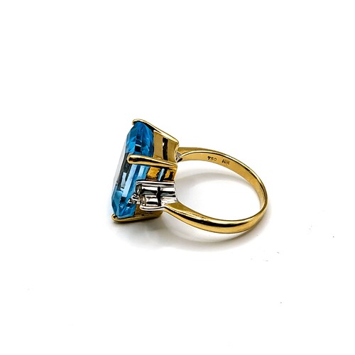 285 - An 18ct yellow gold, diamond, and blue topaz ring, set with three stones to each shoulder (four diam... 