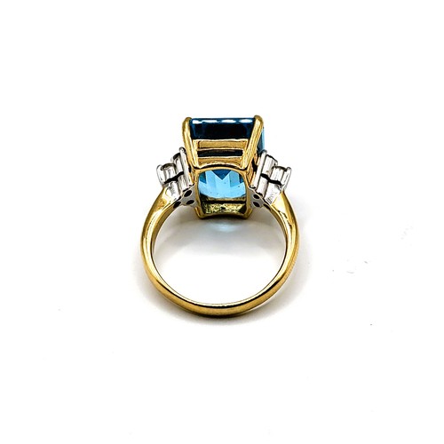 285 - An 18ct yellow gold, diamond, and blue topaz ring, set with three stones to each shoulder (four diam... 