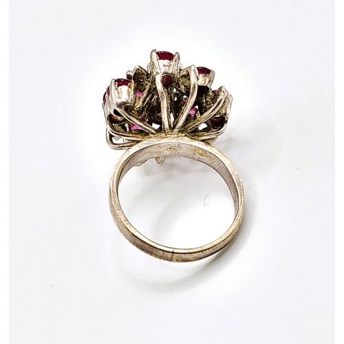 293 - A ruby cluster ring, set with mixed cut rubies, with leaf motif detail inset with small white stones... 