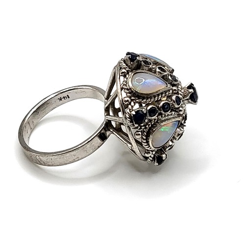 297 - A 14ct white gold, opal, and sapphire ring, of dombed bombe design, inset with pear-cut opals and a ... 