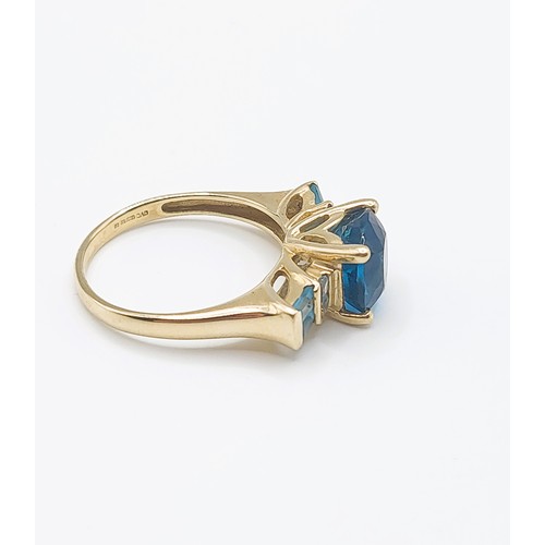 300 - A 9ct yellow gold and blue topaz ring, set with a faceted cushion-cut bright blue topaz, four-claw s... 