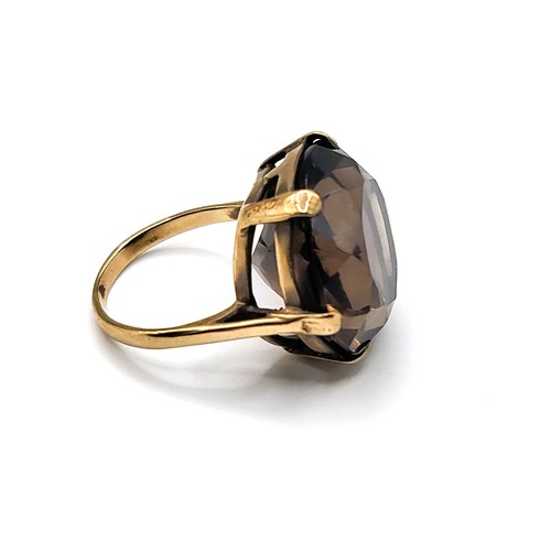 301 - A 9ct yellow gold and smoky quartz cocktail ring, set with a large round-cut quartz, measuring appro... 