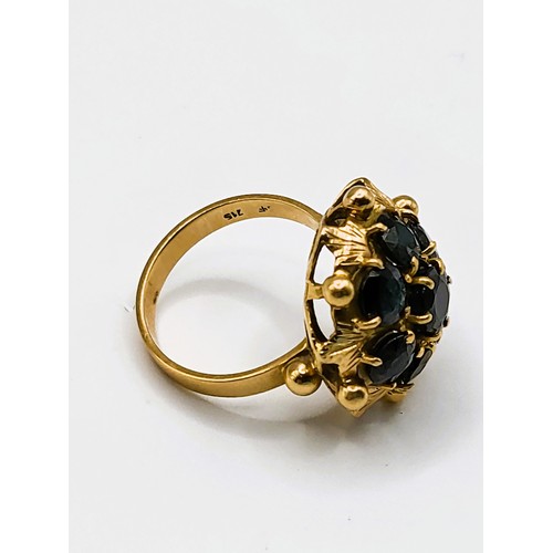 306 - An Italian 18ct yellow gold and sapphire ring, of floral cluster design, set with seven dark blue sa... 