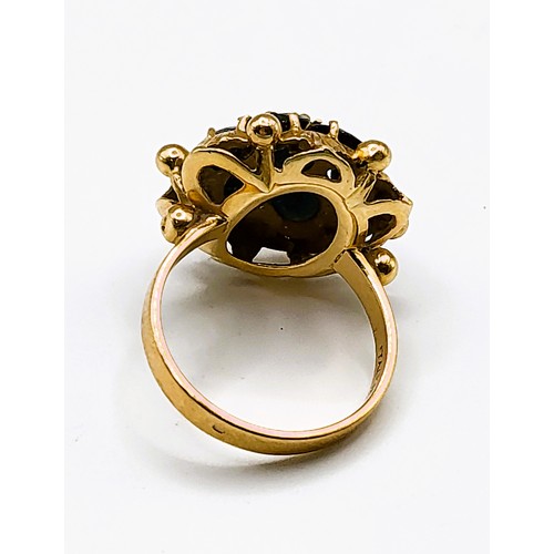 306 - An Italian 18ct yellow gold and sapphire ring, of floral cluster design, set with seven dark blue sa... 