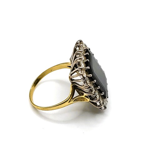 308 - A yellow gold, diamond, and sapphire cocktail ring, set with a flat rectangular-cut dark blue sapphi... 