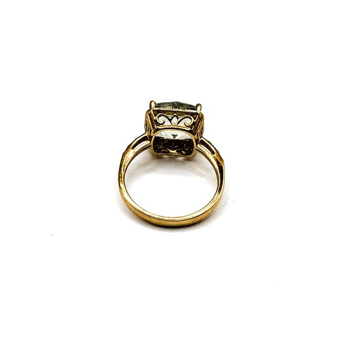 312 - A 9ct yellow gold and prasiolite ring, set with a chequerboard faceted green quartz, surrounded with... 