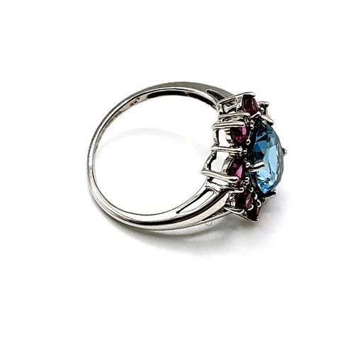 317 - A 9ct white gold, blue topaz, and ruby cluster ring, with small diamond accents, size R.