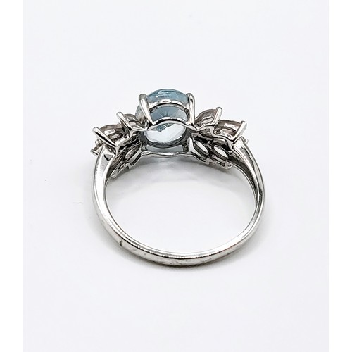 319 - A 9ct white gold, pale blue topaz, and rose quartz ring, set with a mixed oval-cut topaz, with marqu... 