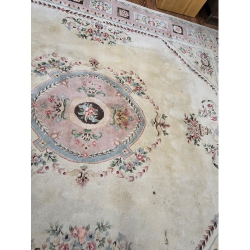 71 - A large Chinese cream ground rug, with polychrome decoration. 270cm x 300cm. In a used condition.