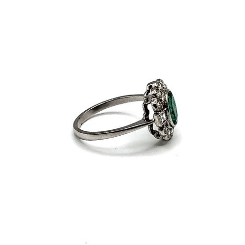 326 - An emerald and diamond cluster ring, set with an oval-cut emerald of approximately 1.20 carats, the ... 