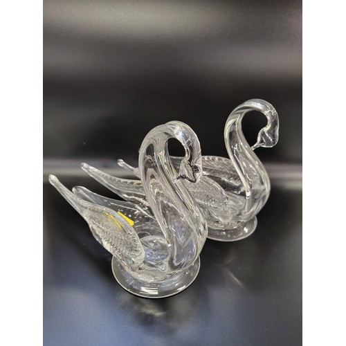 179 - Glass owl, 18cm, hawk, 19cm, and a pair of swans, 19cm. (4)