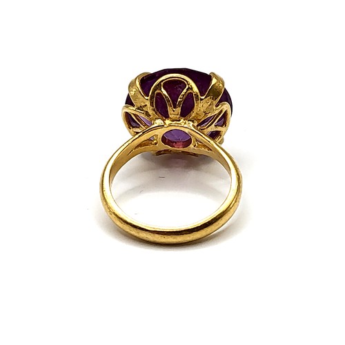 353 - A yellow gold and synthetic colour-change sapphire ring, the purple-hued round-cut stone of approxim... 