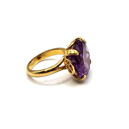 353 - A yellow gold and synthetic colour-change sapphire ring, the purple-hued round-cut stone of approxim... 