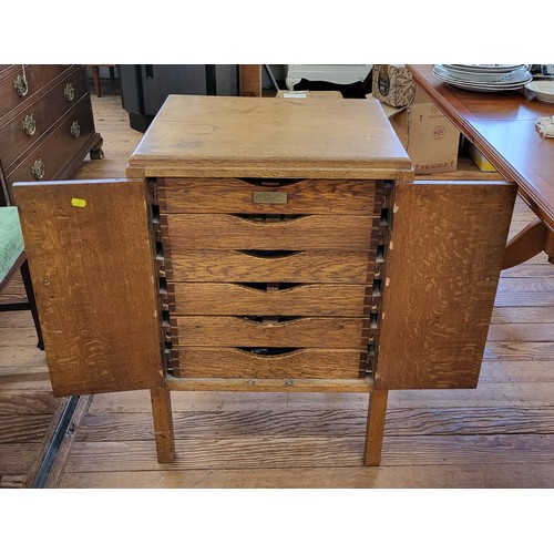 50 - A light oak cutlery cupboard with various cutlery. 79cm x 53cm.