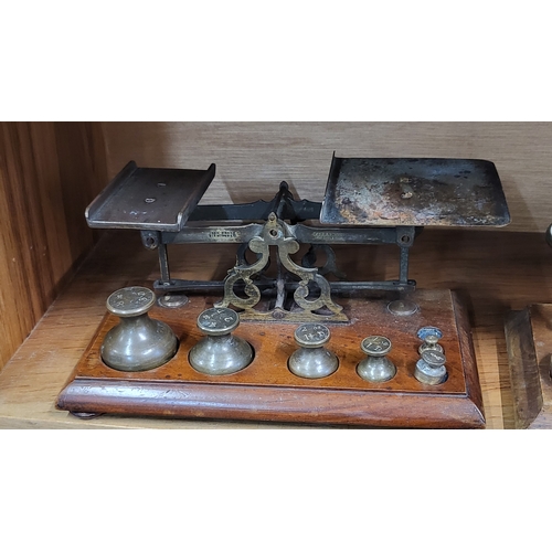 103 - A set of four vintage weighing scales, with brass weights, on wooden base.