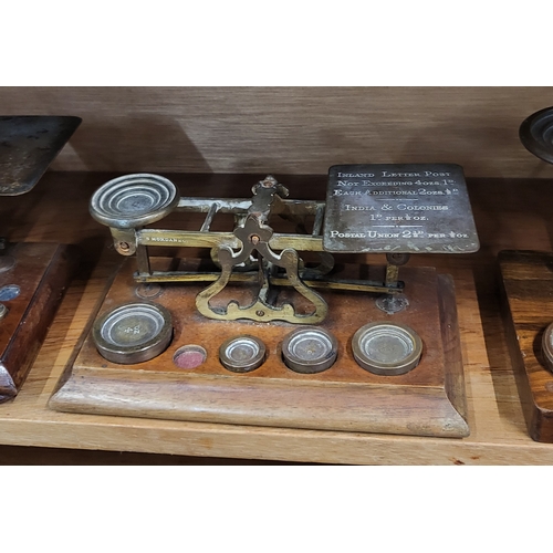 103 - A set of four vintage weighing scales, with brass weights, on wooden base.